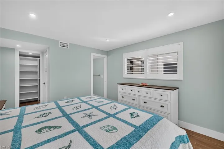 Recessed lighting, wood-finish flooring, and a built-in shelving unit