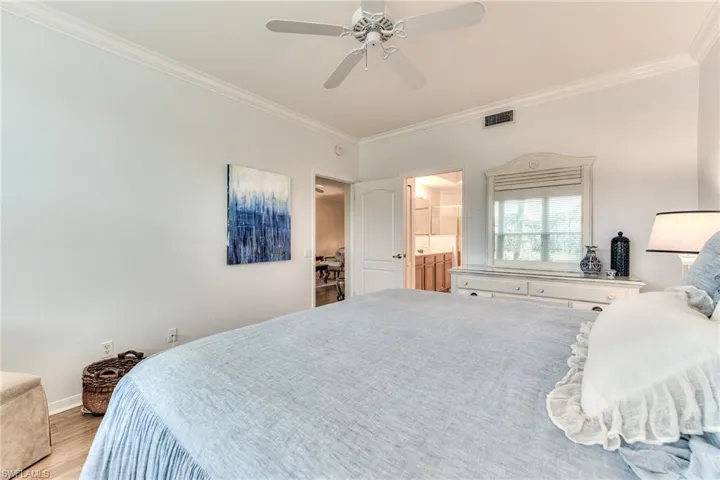 Bedroom featuring ceiling fan, crown molding, connected bathroom, and light hardwood / wood-style flooring