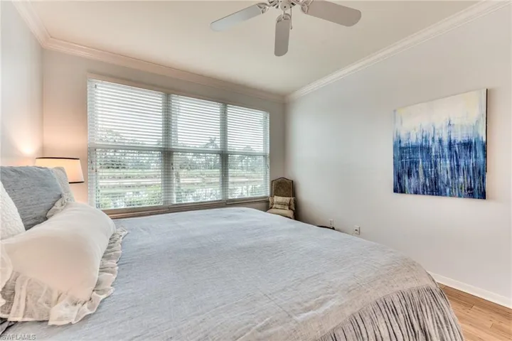 Bedroom featuring light wood-type flooring, ceiling fan, and crown molding