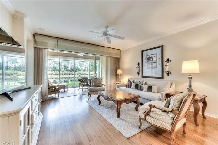 Living room with light hardwood / wood-style flooring, ceiling fan, and crown molding