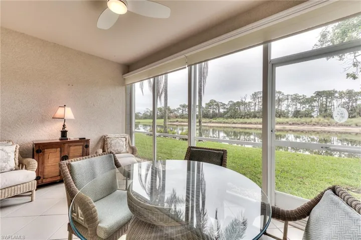 Sunroom / solarium featuring ceiling fan and a water view
