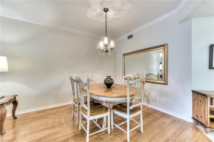 Dining room with light hardwood / wood-style flooring, a notable chandelier, and ornamental molding