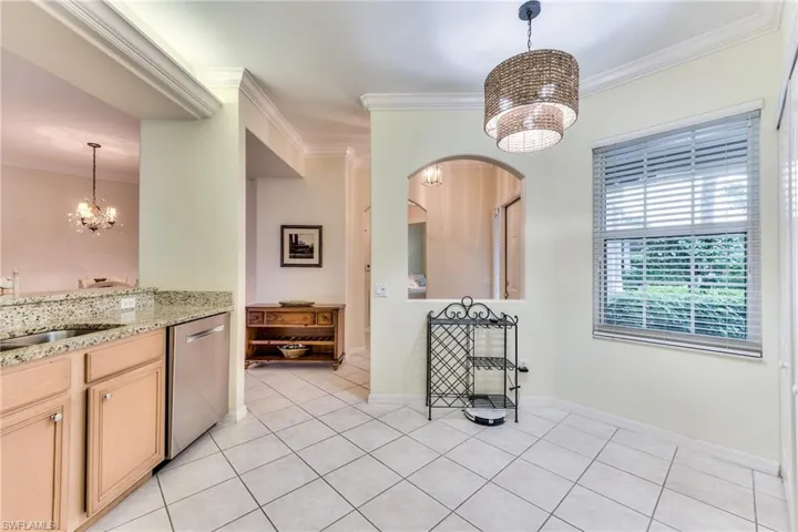 Kitchen featuring decorative light fixtures, sink, a chandelier, and stainless steel dishwasher