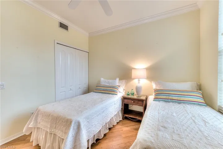 Bedroom with light hardwood / wood-style floors, a closet, ornamental molding, and ceiling fan