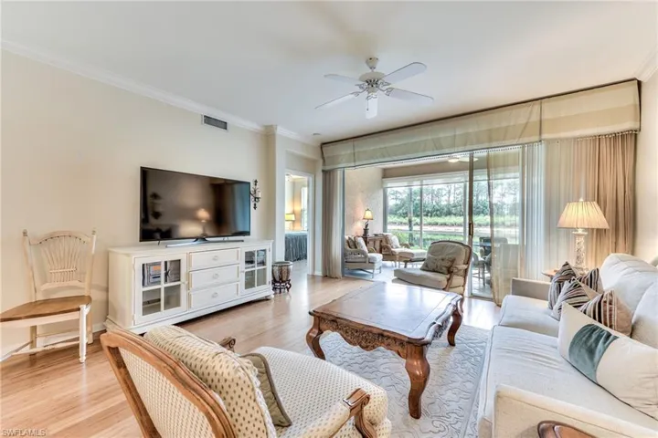 Living room with light hardwood / wood-style flooring, ceiling fan, and crown molding