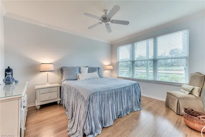 Bedroom featuring ceiling fan, crown molding, and light hardwood / wood-style flooring