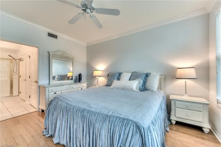 Bedroom with ceiling fan, light wood-type flooring, and crown molding