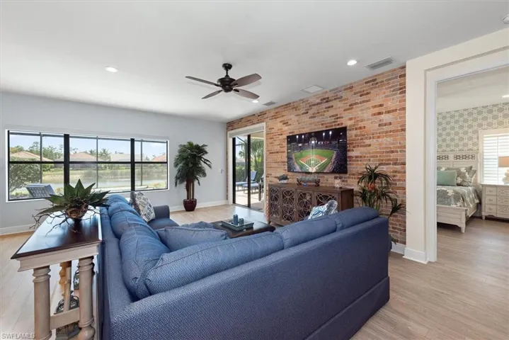 Living room featuring baseboards, a ceiling fan, light wood finished floors, plenty of natural light, and recessed lighting