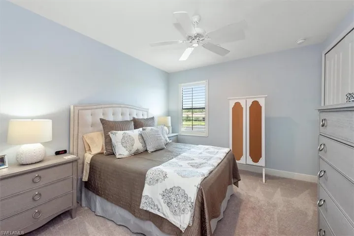 Bedroom featuring light carpet, ceiling fan, and baseboards