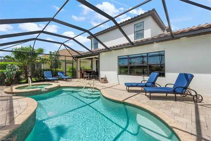 View of swimming pool with a patio, a pool with connected hot tub, and a lanai