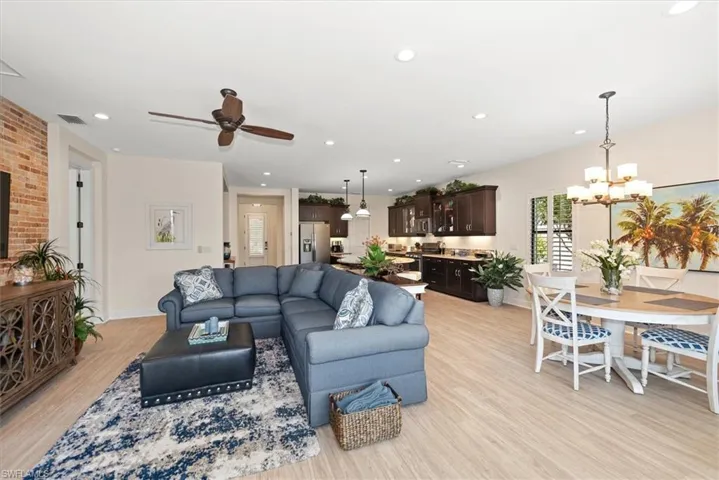 Living area featuring light wood-type flooring, ceiling fan, a chandelier, baseboards, and recessed lighting