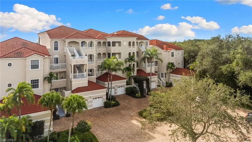 View of property featuring decorative driveway and a garage