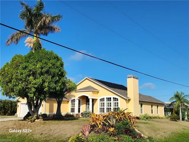 View of front of home with a garage and a front lawn