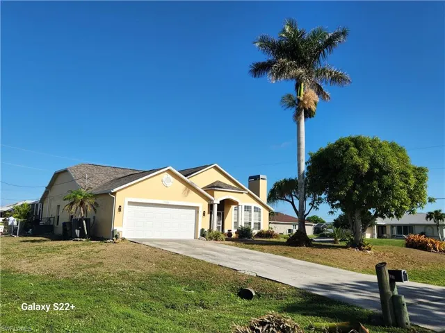 View of front of property with a garage and a front yard