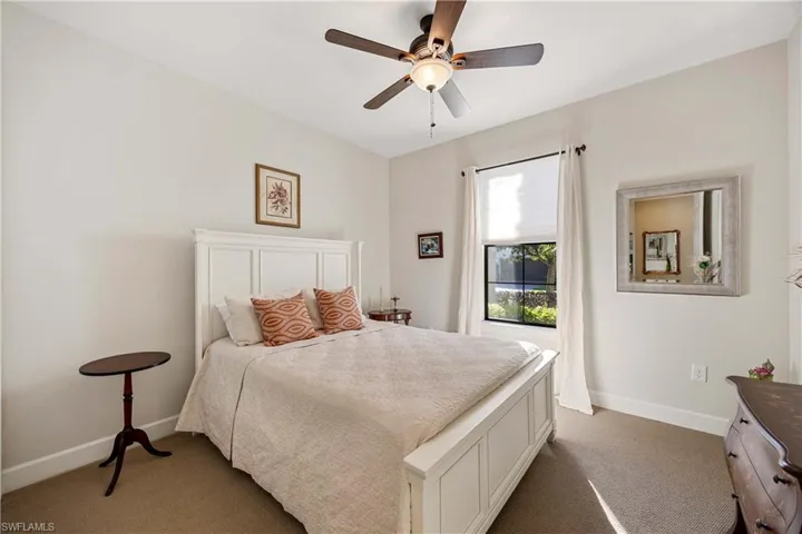 The carpeted guest bedroom with large window and full closet