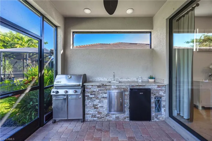 The outdoor kitchen with grill, fridge and sink on the covered lanai makes everyday grilling and entertaining easy and convenient.
