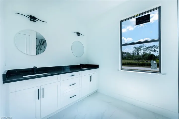 Bathroom with tile floors, large vanity, and double sink