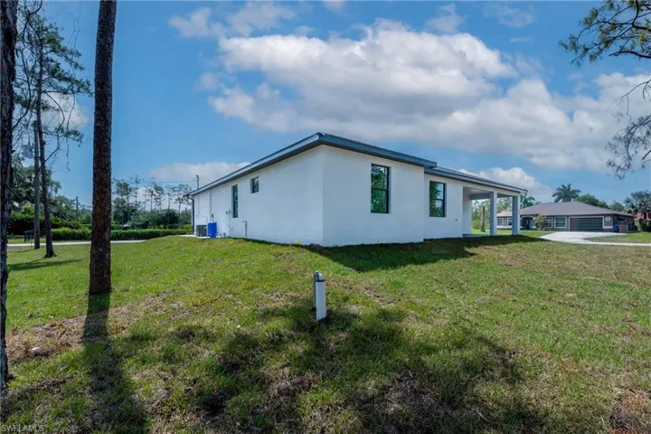 View of side of home with a yard