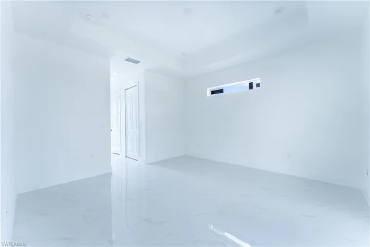 Tiled spare room with a tray ceiling