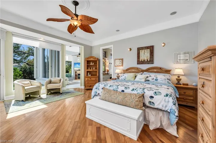 Wood floors, large windows, crown molding, and a peek of the den/office.
