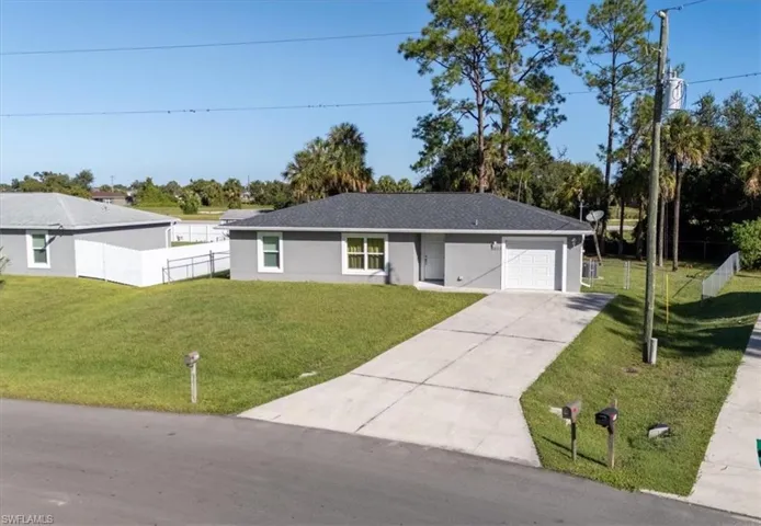 Ranch-style house with concrete driveway, a garage, and stucco siding
