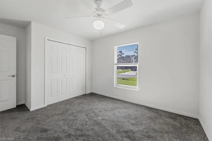 Unfurnished bedroom featuring carpet flooring, a closet, and ceiling fan