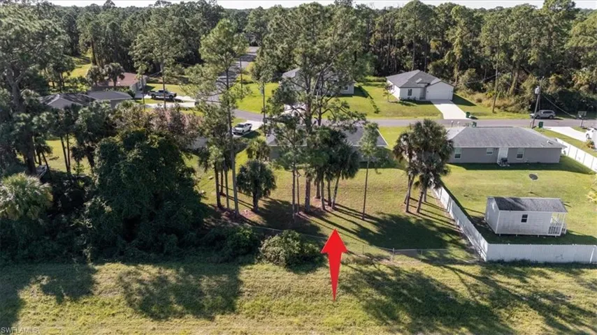 Aerial view of property and surrounding area with a forest