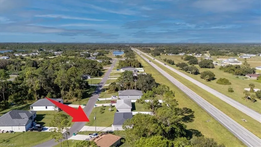 Aerial view of property and surrounding area with nearby suburban area