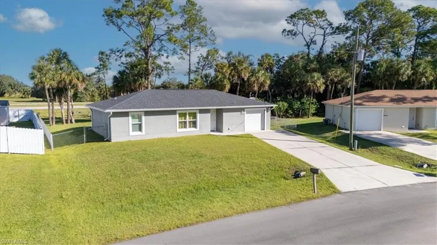 Ranch-style house featuring concrete driveway, stucco siding, and a garage