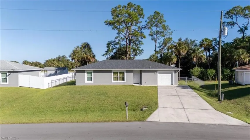 Ranch-style home with concrete driveway, a garage, and stucco siding