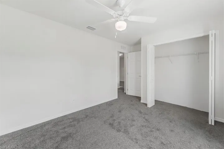 Unfurnished bedroom featuring carpet, a closet, and ceiling fan