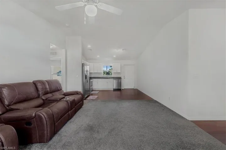 Living room featuring dark carpet and dark wood-style floors