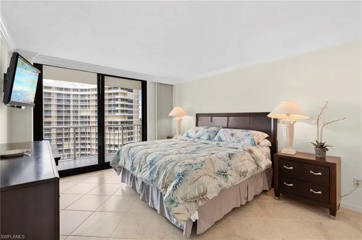 Tiled bedroom featuring crown molding and access to exterior