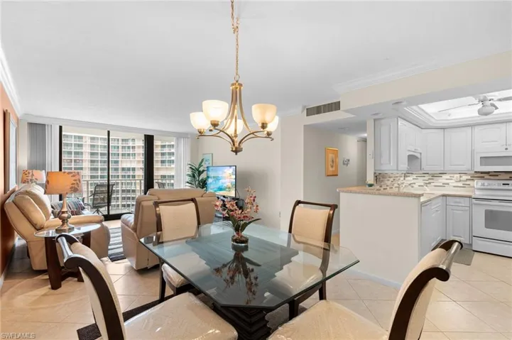 Tiled dining area with crown molding and a chandelier