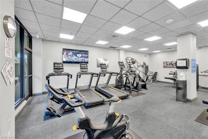 Workout area featuring carpet floors and a drop ceiling