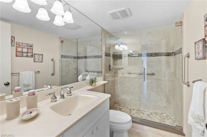 Bathroom with walk in shower, vanity, and toilet