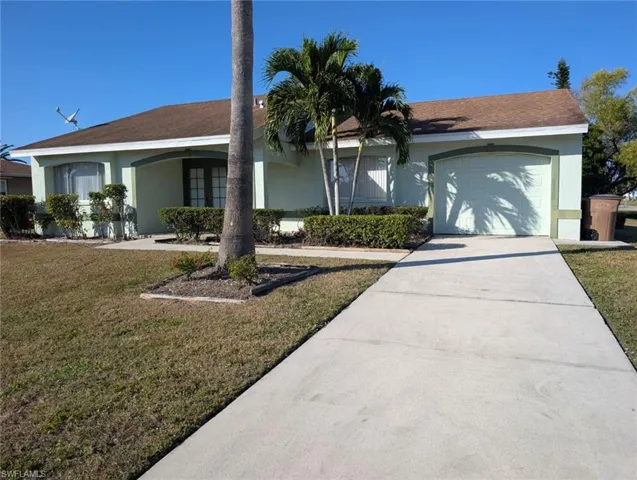 Ranch-style house featuring stucco siding, concrete driveway, and a front yard