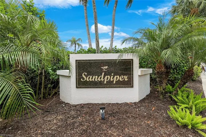 Sandpiper community entry sign with a dark stone plaque featuring gold lettering