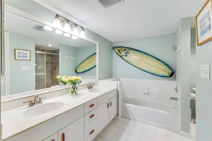 Bathroom featuring an extended double vanity with integrated sinks, brushed nickel faucets, and under-cabinet storage