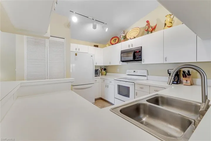 Kitchen with white cabinetry, a double basin stainless steel sink, and a high-arch faucet