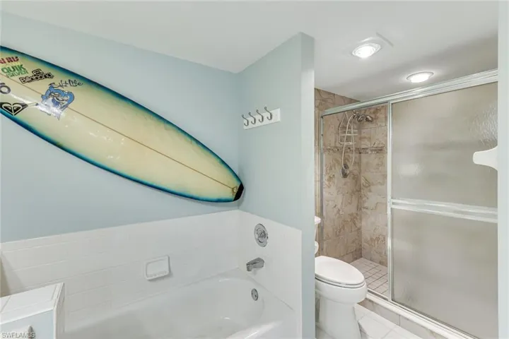 Bathroom featuring a bathtub with subway tile surround, tiled shower with sliding glass door, and recessed lighting