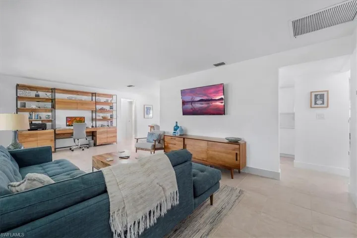 Living room with an office area and light tile patterned floors