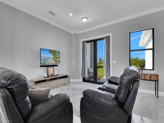 Living area featuring marble finish floor, baseboards, and ornamental molding
