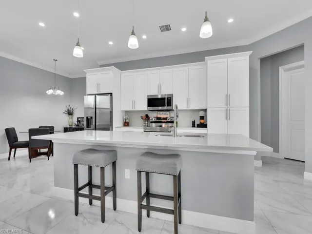 Kitchen with visible vents, stainless steel appliances, marble finish floor, and a sink