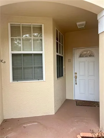 Property entrance featuring stucco siding and covered porch