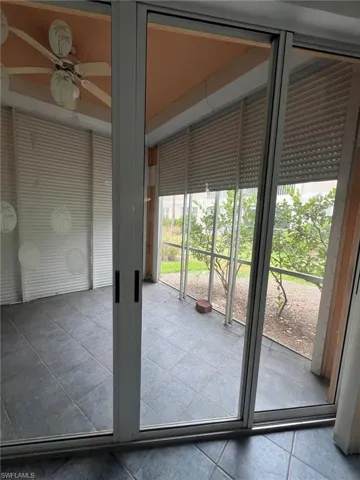 Doorway featuring tile patterned flooring and ceiling fan