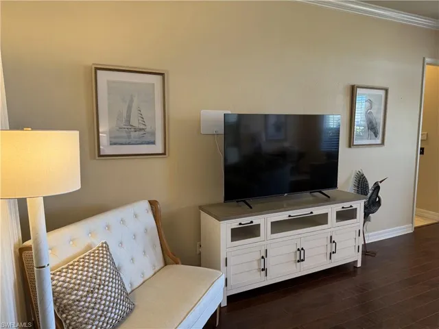 Living room with ornamental molding, baseboards, and dark wood finished floors