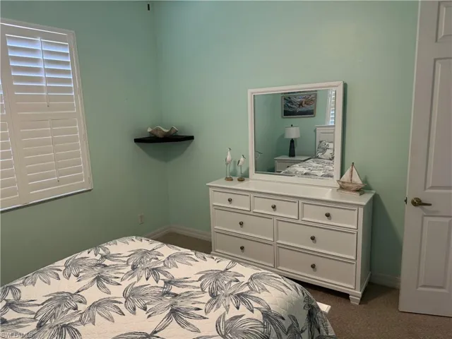 Bedroom with dark carpet and baseboards