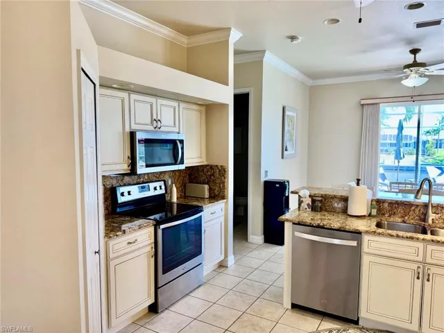 Kitchen with a sink, visible vents, decorative backsplash, crown molding, and appliances with stainless steel finishes