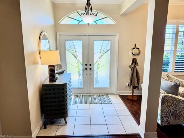 Foyer with baseboards, ornamental molding, french doors, and tile patterned floors